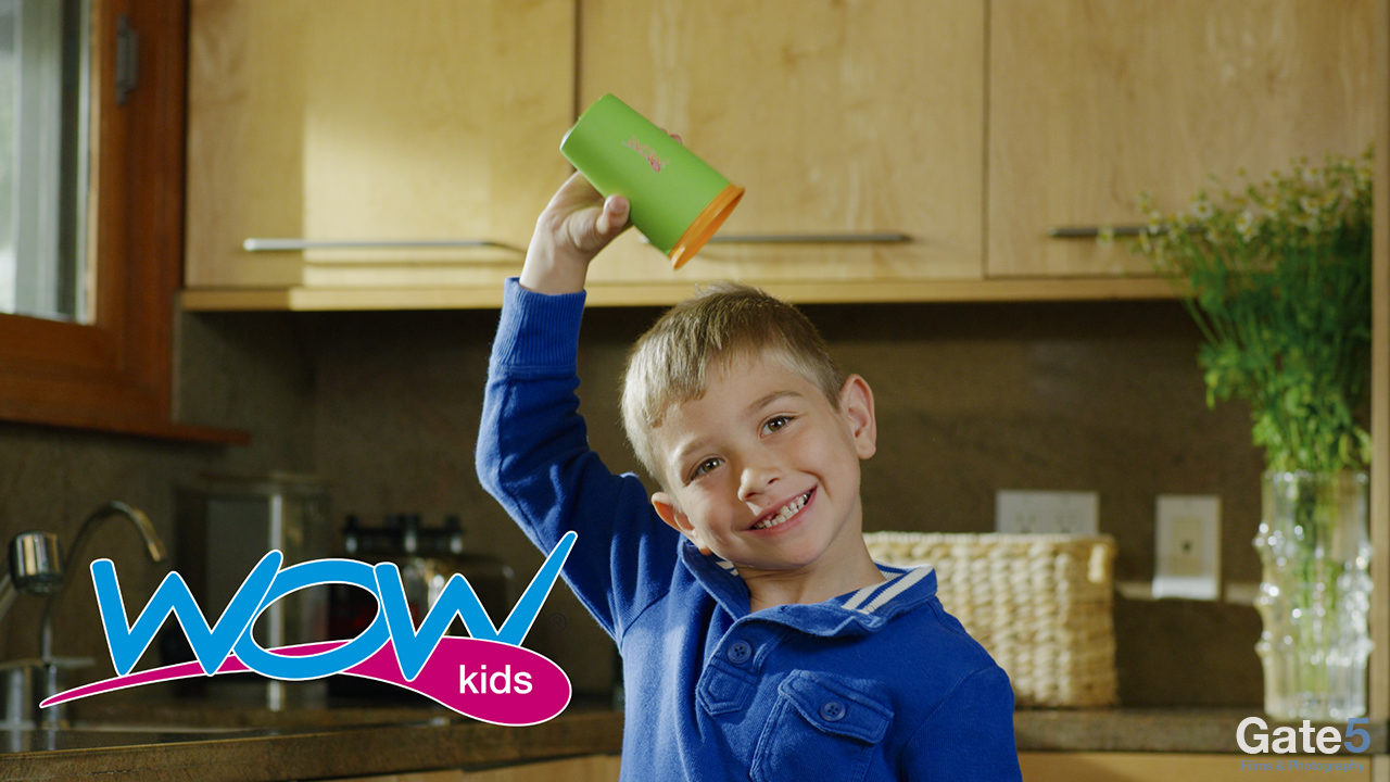 a kid holds a spill free sippy cup over his head in a video ad