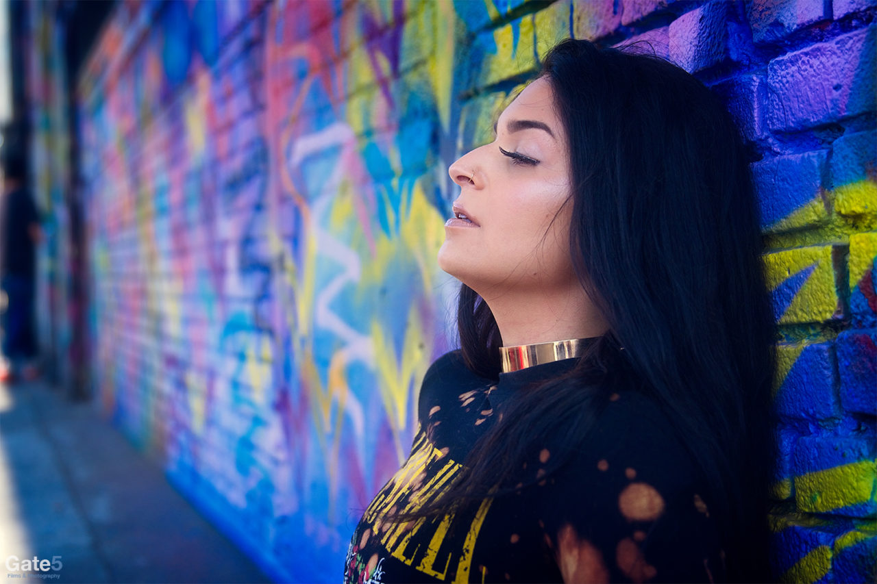 female model against colorful wall with graffiti art