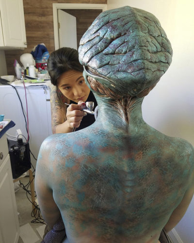 Alien body paint on actor’s back behind the scenes