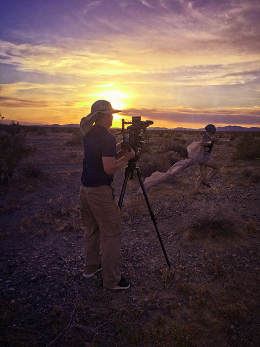 an alien runs past camera at sunset in the desert in BTS shot