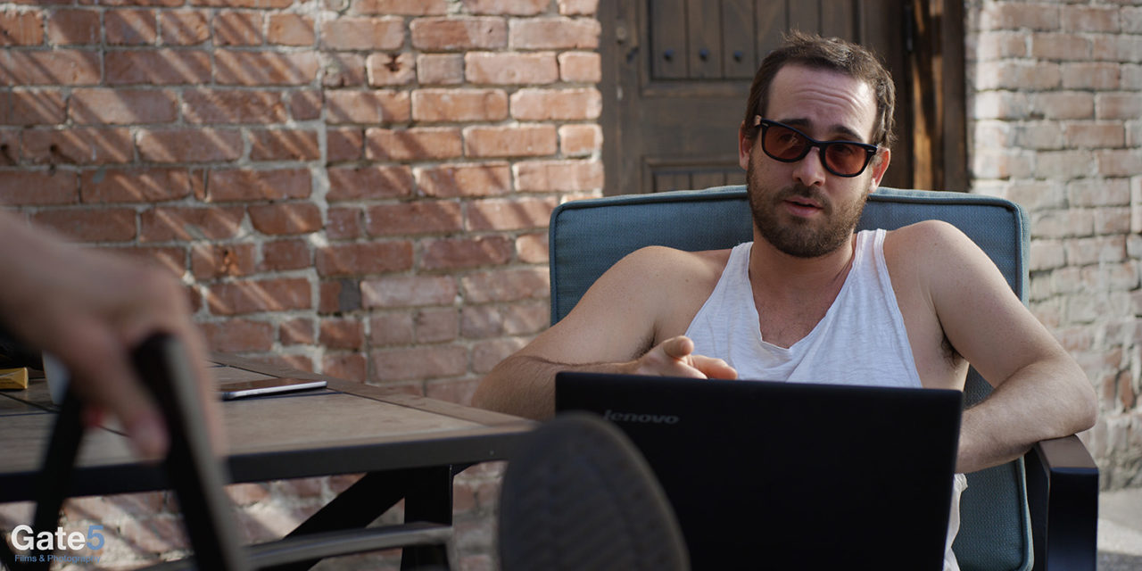 when location scouting, think of a location that can double as another like here with a man writing a screenplay outside at a coffee shop in a comedy film 