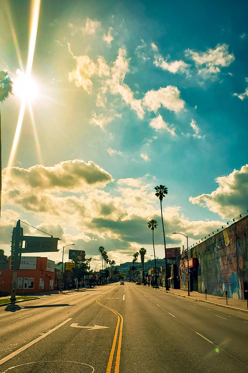 An empty Sunset Blvd in Hollywood during Coronavirus stay at home order on a sunny day with puffy clouds