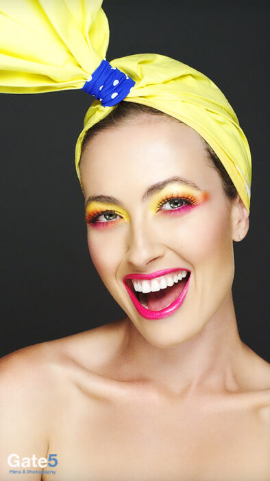 model in beauty video smiling with red lips and color makeup